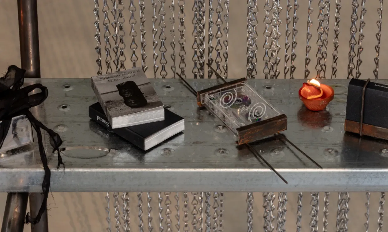 Close up shot of a cassette, two little notebooks and a candle light.