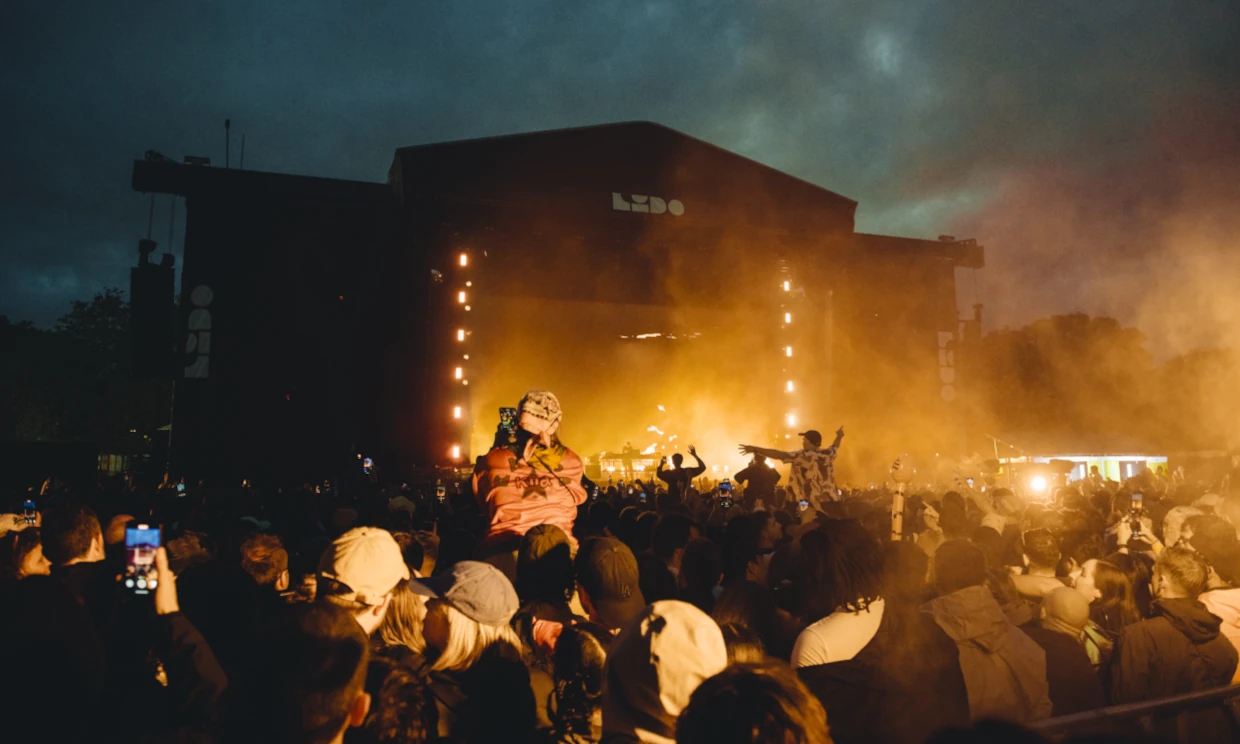 A large festival crowd gathered around a LIDO stage.