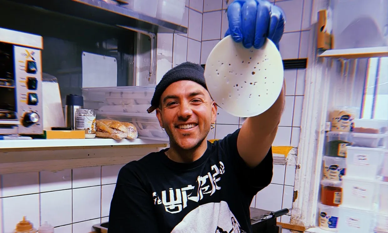 A kitchen staff member holding a pickled mooli