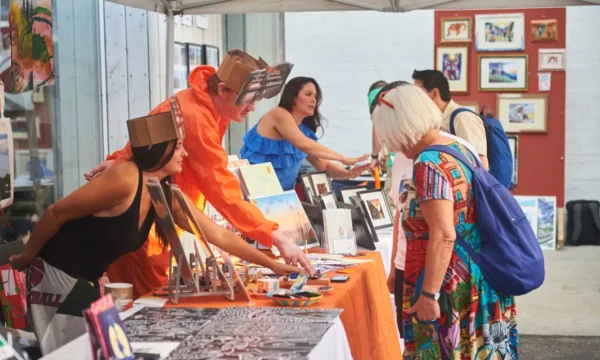 Visitors at a colourful makers market style setting.