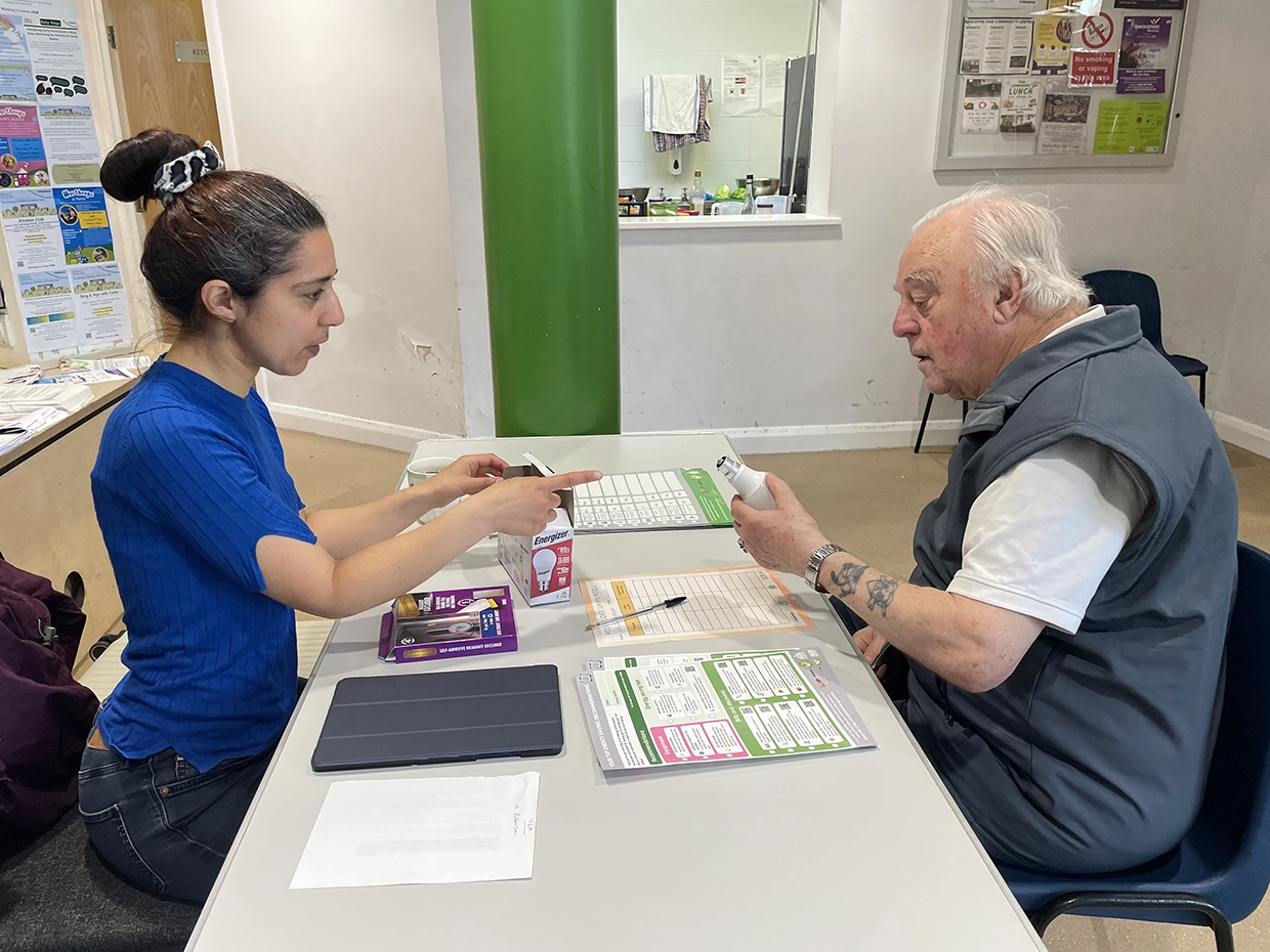 A Crew Energy staff member helping an elderly man