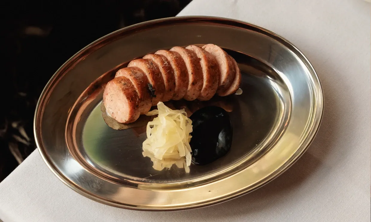 A long sausage sliced into circular pieces, with a sauerkraut accompaniment