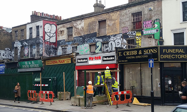 Workers erect hoardings around shop facades in November 2016