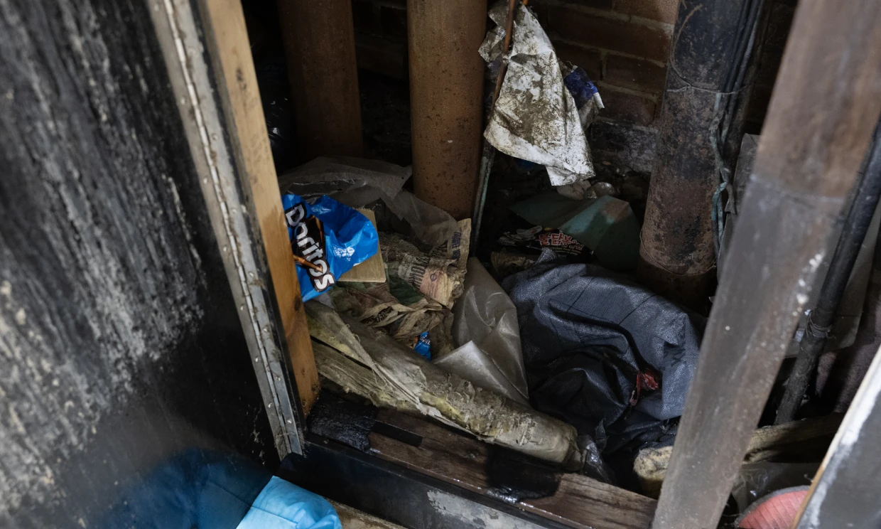 An open wall cavity showing rubbish inside it
