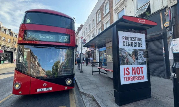 Greenpeace activists displayed posters opposing the proscription of Palestine Action at bus stops across London