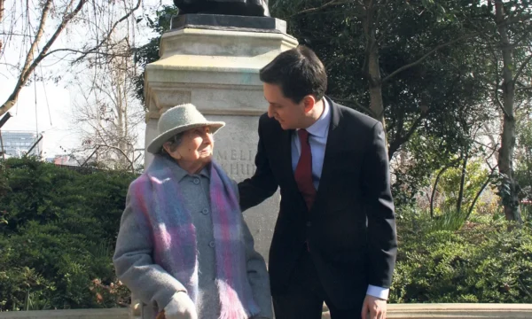 Hetty, an old woman, is standing with politician Ed Miliband in front of a statue