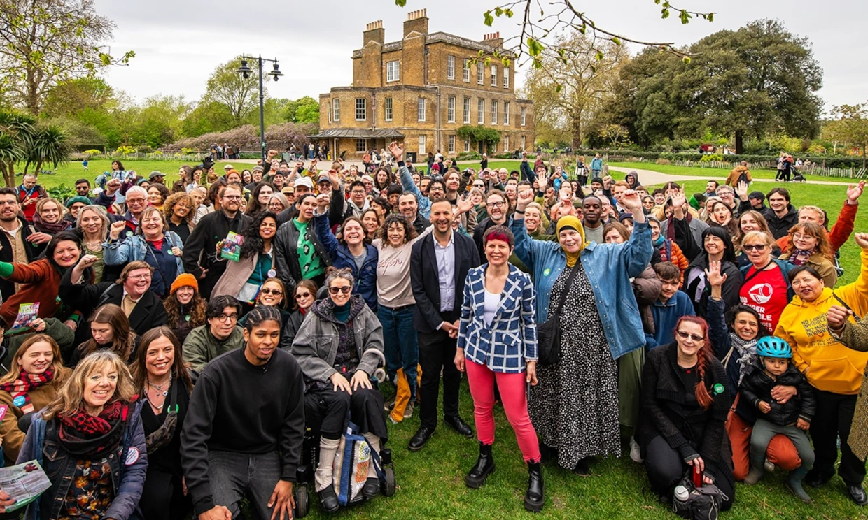 Zoe Garbett stands in front of a large crowd outside.