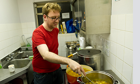 Volunteer Tom Curtis prepares a meal for guests at the shelter. Photograph: Nick Curtis