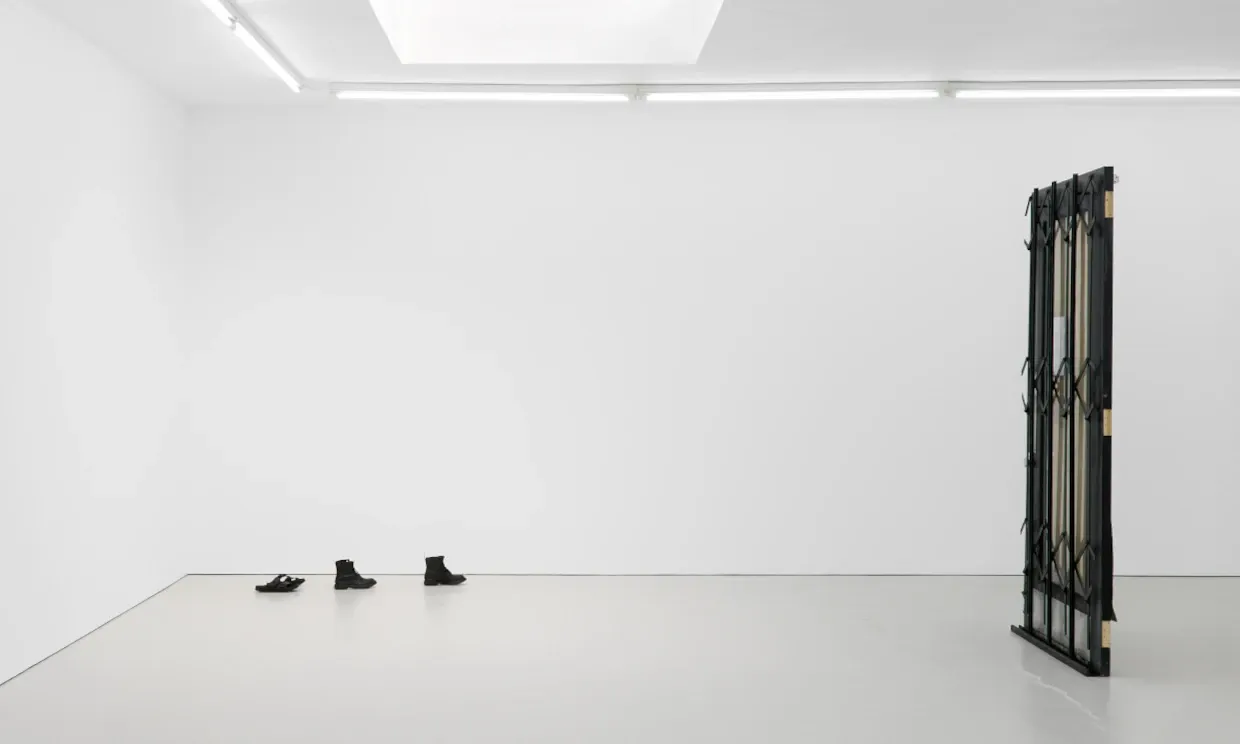 Bronze casts of shoes feature next to a door in Fiona Connor's I haven’t arrived yet, Closed Down Clubs installation