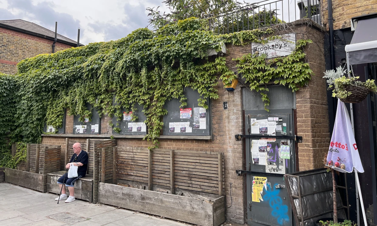 The outside of the derelict loos. They are overgrown with leaves.
