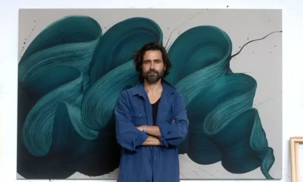 Artist Kostas Papakostas standing in front of a piece of his art.