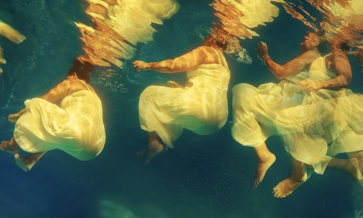 The artwork, in which multiple black women are moving through blue water in different shapes