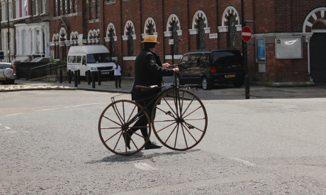 Sergeant Buzfuz crossing Downs Road with the bone-shaker bicycle.