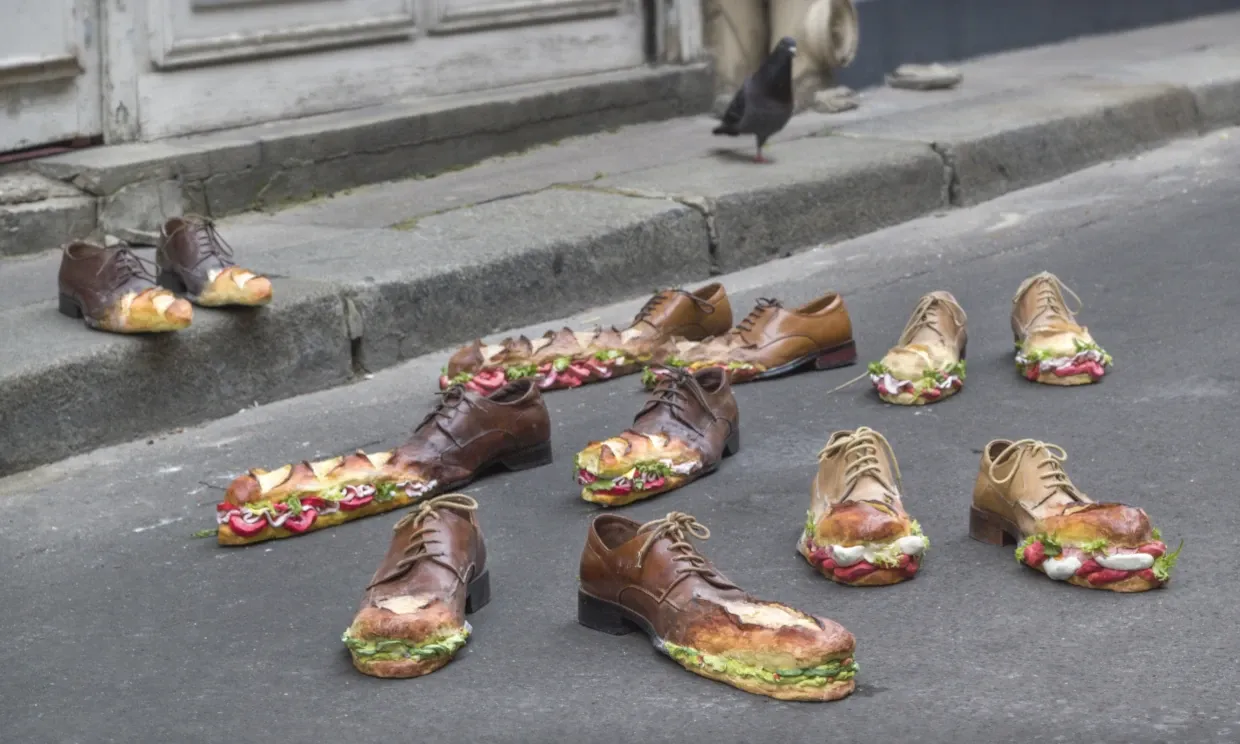 A street installation in which shoes morph into different baguette sandwiches on the road.