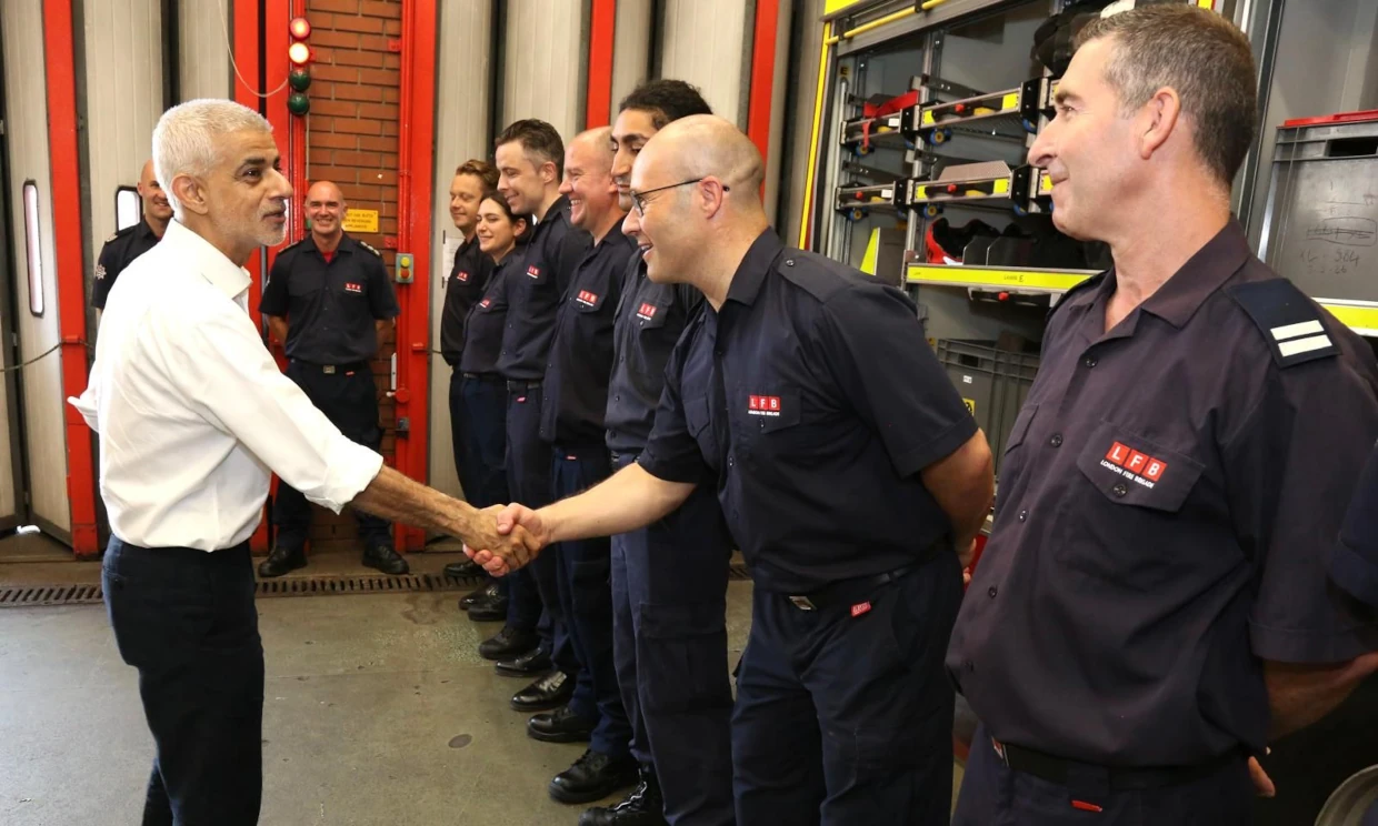 Sadiq Khan shakes the hand of members of the fire service