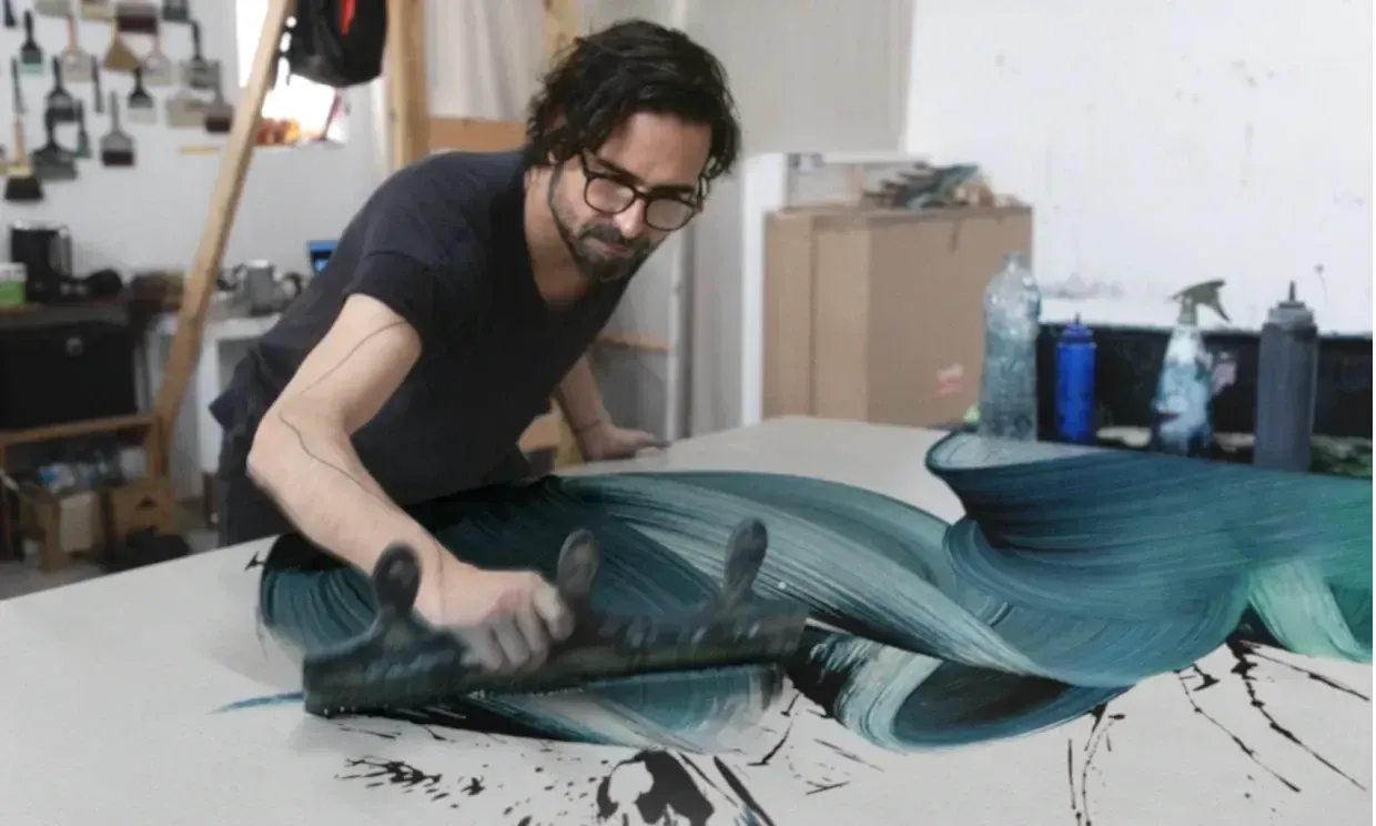 Kostas Papakostas painting on canvas with a large custom-made brush.