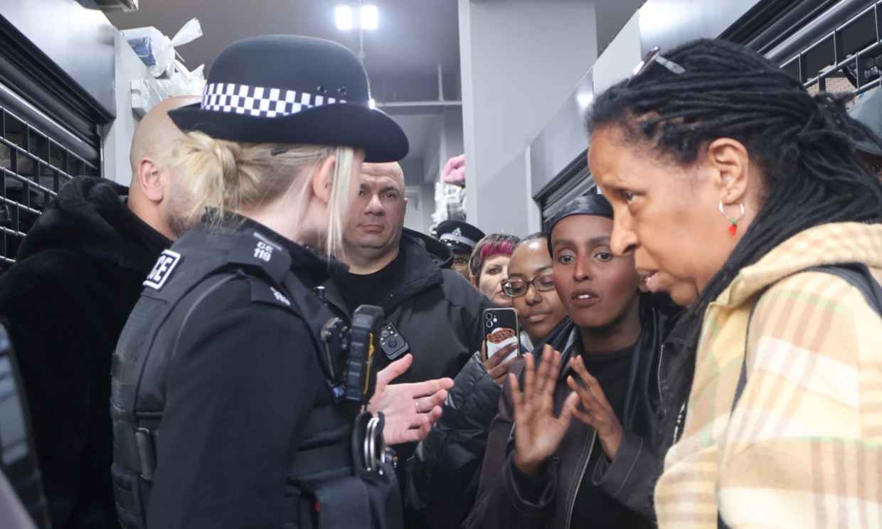 Women argue with two members of police inside the market.