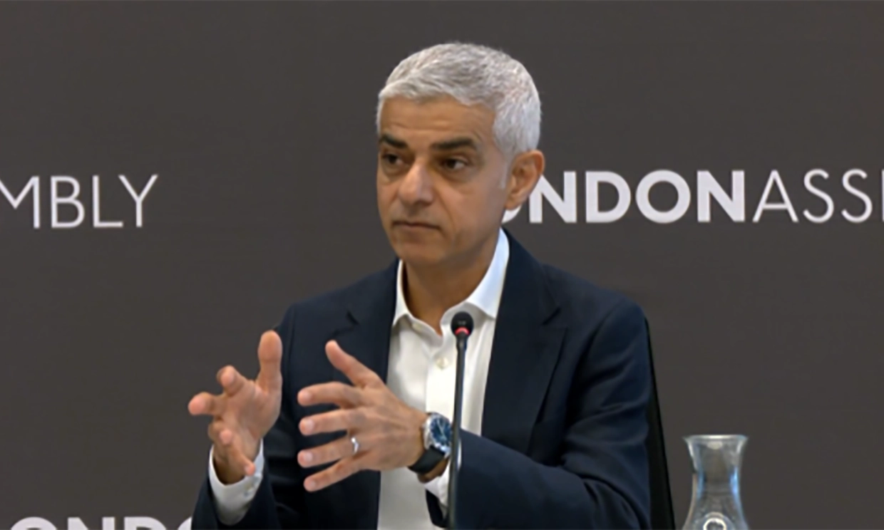 Khan talking and gesticulating at a question desk