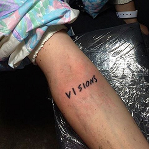 A Visions devotee shows off their tattoo